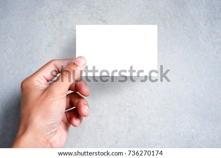 Hand holding blank plain white business card design mock up. Clear call id card mock up template hold arm. Visit pasteboard paper surface display front. Small pure offset name card print.Logo branding