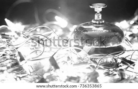 reception bell on the table and color shining garland on background