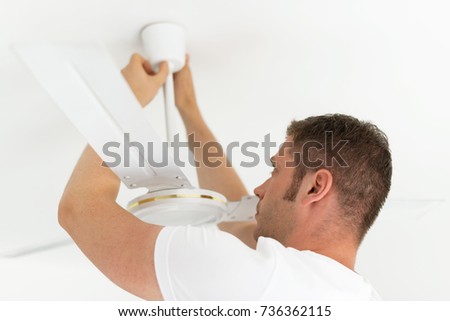 Male technician installing ceiling fan. Royalty-Free Stock Photo #736362115