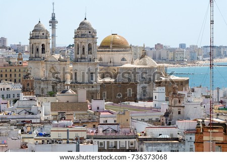 Aerial panoramic view of the old city rooftops and Cathedral de Santa Cruz from tower Tavira in Cadiz, Andalusia, Spain, an ancient port city, built on a strip of land surrounded by sea..