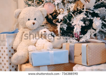 Teddy bear toys and colorful  gifts boxes under the christmas tree