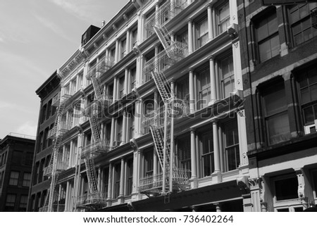 Black and white image of fire escape ladders on a New York building