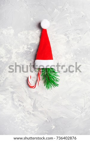 Christmas and New Year signs - red Santa hat, fir tree and candy over grey background
