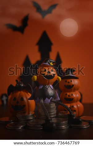 Halloween pumpkins jack-o-lantern with money coin stack growing business on dark orange background. Happy Halloween.