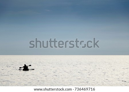 silhouette people boating canoe boat in sea on vacation time for relax at Teay Ngam Beach, Thailand. Blue tone look beautiful.