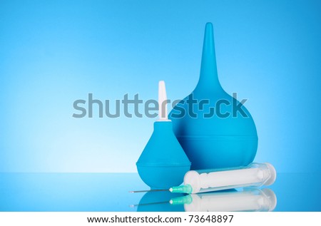 Blue rubber pear and syringe. Clyster. on blue background