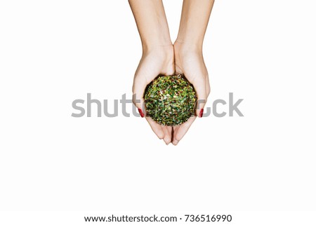 Hands of young woman holding a ball with beads for Christmas decoration, isolated on white background