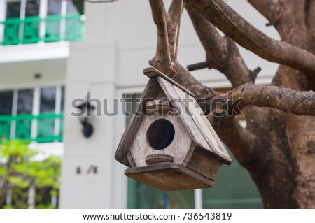 Classic wooden birdhouse on tree in park.