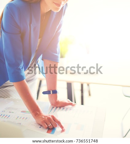 Woman sitting on the desk with laptop.