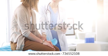 Doctor and patient discussing something while sitting at the table . Medicine and health care concept. Doctor and patient Royalty-Free Stock Photo #736552108