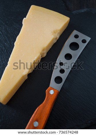 cheese knife with a wooden handle over black