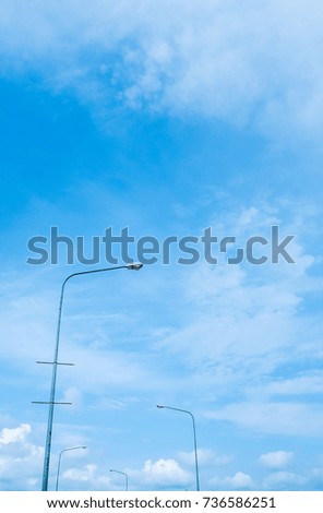 Street lamps with clear brilliant blue sky with windy cloud.