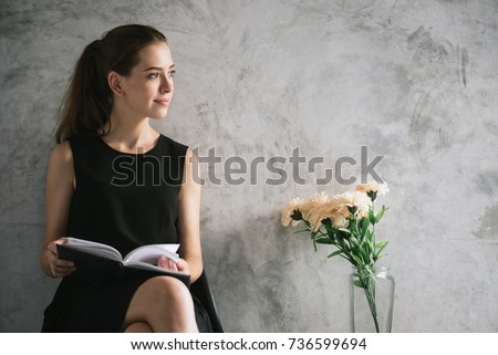 Portrait of a beautiful young woman reading book relaxing in living room. Vintage effect style pictures.