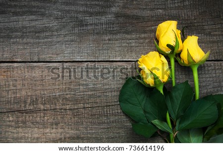 Yellow roses on a old wooden table