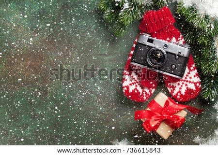 Xmas greeting card. Christmas background with snow fir tree, camera and gift box. View from above with space for your greetings or photo