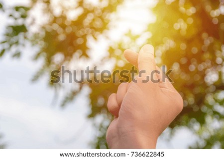Mini heart sign by hand on the air with sun flare