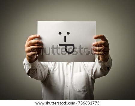 Man is holding white paper with smile.Tongue out and smiling concept.
