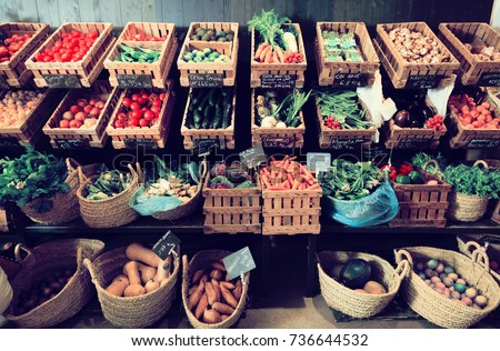 vegetables and fruits in wicker baskets on counter of greengrocery. on labels of product names in Catalan Royalty-Free Stock Photo #736644532