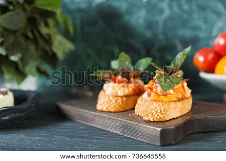 Snack, bruschetta, sandwich on a wooden board. Tomatoes, aubergines, bread. Place for text.