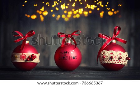 red Christmas balls with ribbon on dark wooden background                               