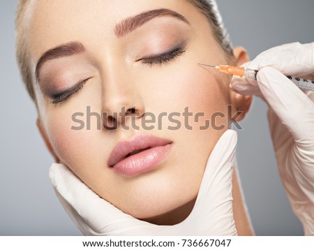 Woman getting cosmetic injection of botox near eyes, closeup. Woman in beauty salon. plastic surgery clinic. Royalty-Free Stock Photo #736667047