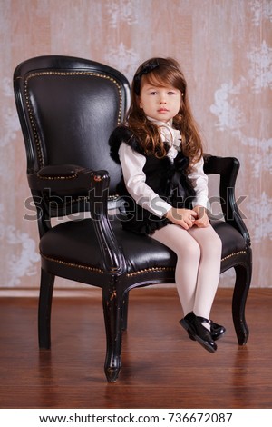Young brunette dolly lady girl stylish dressed like a boss in white official shirt black skirt posing sitting in studio on black leather chair with pout lips and pink cheeks
