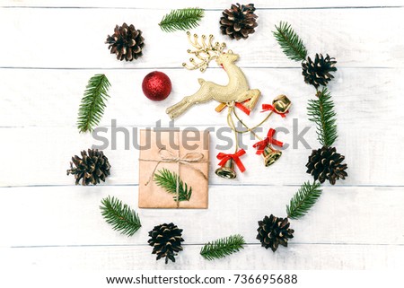 White wooden christmas background. The frame is decorated with evergreen twigs of thuja and flowers. Original, fresh floral design for xmas card.  Winter holiday greetings. 
