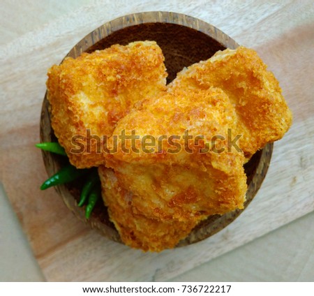 top view, tahu sumedang (Fried Tofu) from west java,  indonesia with green hot chili at Wooden small bowl
