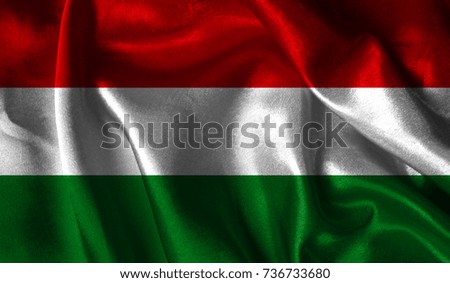 Realistic flag of Hungary on the wavy surface of fabric. This flag can be used in design.
