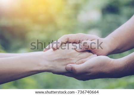 Two people holding hand together over blurred nature background,Business man and woman shaking hands,helping hand  and world peace concept with copy space Royalty-Free Stock Photo #736740664