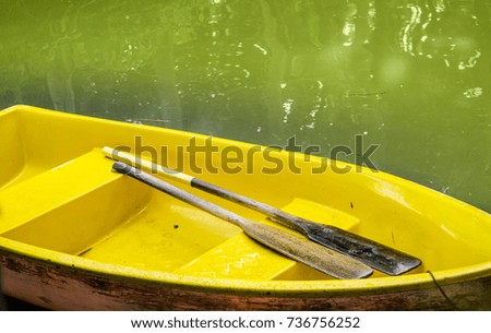 Yellow boat with two paddles in the canal.