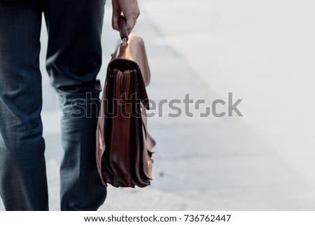 Cropped view of businessman holding briefcase outdoors. Free space on the right