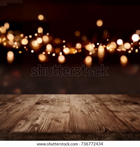 Festive dark background with golden light effects and empty wooden table for a christmas decoration