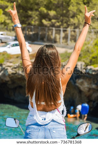 Girl with raised hands on a bike