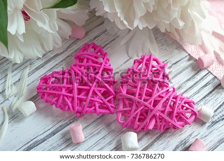 Peonies flowers rattan hearts marshmallow on a white wooden background - stock image.