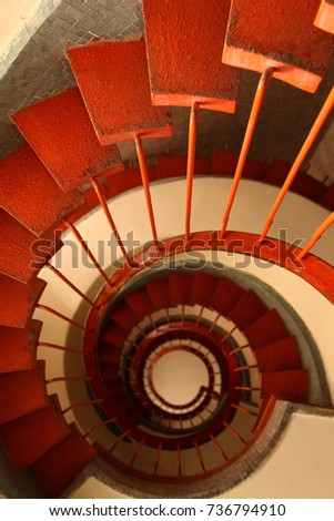 Photo of red stairs within opposite angle. Like rabbit hole from Wonderland.