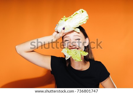 the lovely girl was tired of chewing cabbage and put it to her head. Healthy food, delicious vegetables, diet.