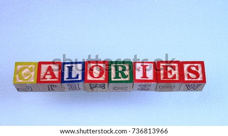 The term calories visually displayed on a clear background using colorful wooden toy blocks in landscape format with copy space