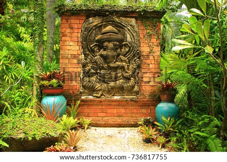 photo background for photo montage. bas-relief with sitting elephant set amidst tropical vegetation