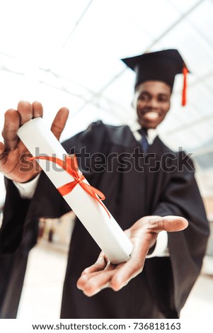 close-up shot of happy african american graduated student showing diploma
