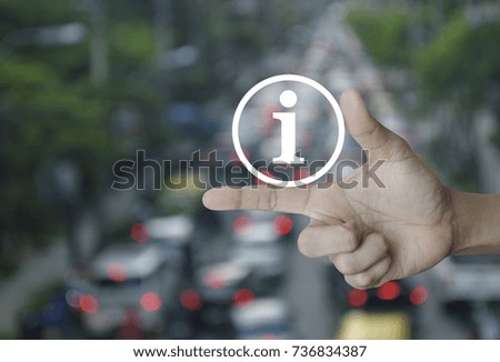 Information sign icon on finger over blur of rush hour with cars and road, Business communication concept