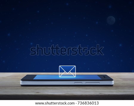 email icon on modern smart phone screen on wooden table over fantasy night sky and moon, Business communication concept