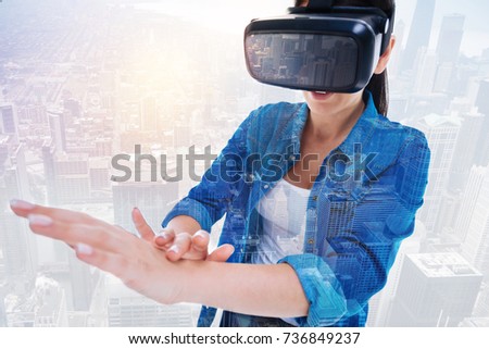 Smiling woman in VR headset touching her hand