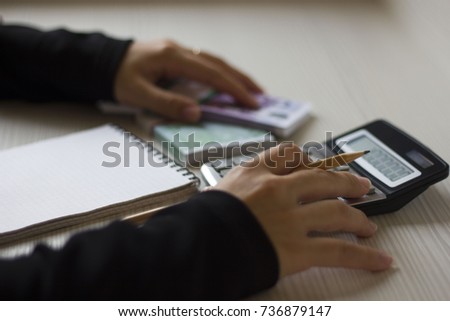 Accounting. business woman counts money on calculator