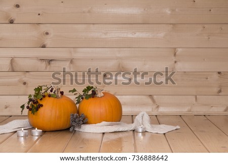 Two pumpkins in wooden log cabin with negative space for text