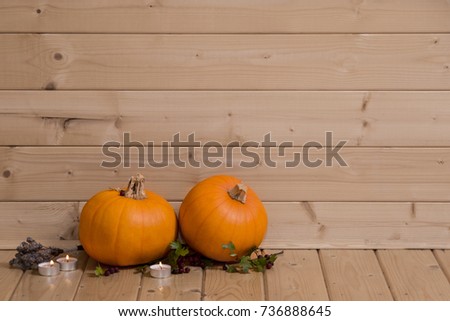 Two pumpkins in wooden log cabin with negative space for text


