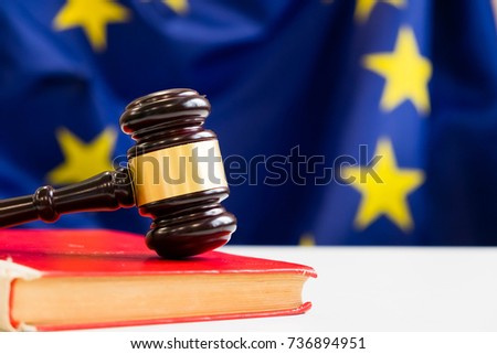 Judges wooden gavel with EU flag in the background. Symbol for jurisdiction. Wooden gavel on european union flag Royalty-Free Stock Photo #736894951