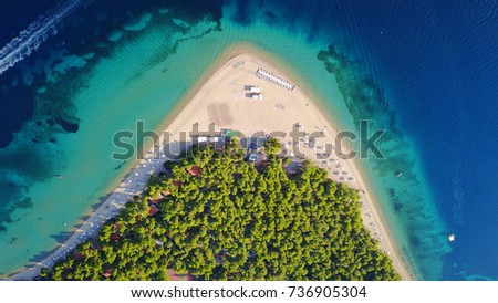 Aerial bird's eye view photo taken by drone of tropical seascape and sandy beach with turquoise clear waters and pine trees