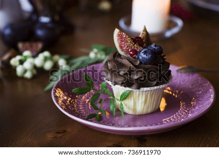 Chocolate cupcake with figs and berries on the festive table