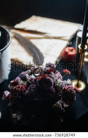 Bouquet of dark flowers stands on a black table